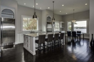 A kitchen with dark wood floors and white cabinets.