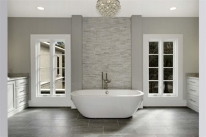 A bathroom with a large tub and tiled walls.