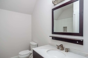 A bathroom with a sink, mirror and toilet.