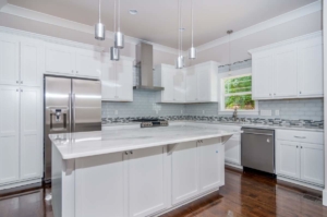 A kitchen with white cabinets and stainless steel appliances.