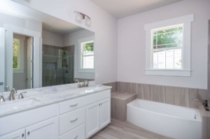 A bathroom with white cabinets and a large mirror.
