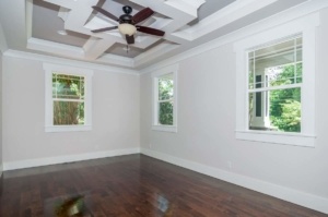 A room with wood floors and ceiling fans.
