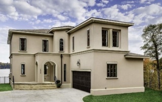 A large white house with a driveway in front of it.