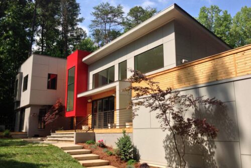 Modern gray and wood exterior with a bold red stair volume in Providence Plantation