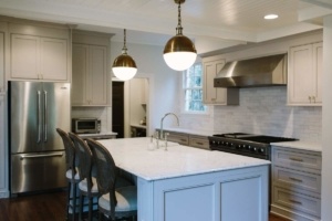 A kitchen with white cabinets and gold fixtures.