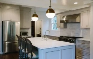 A kitchen with white cabinets and gold fixtures.