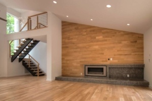 A living room with wood walls and stairs