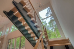 A staircase with metal railing and wood steps.