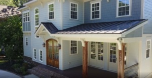 A blue house with white trim and black roof.
