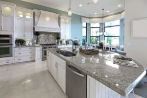 A large kitchen with granite counter tops and white cabinets.