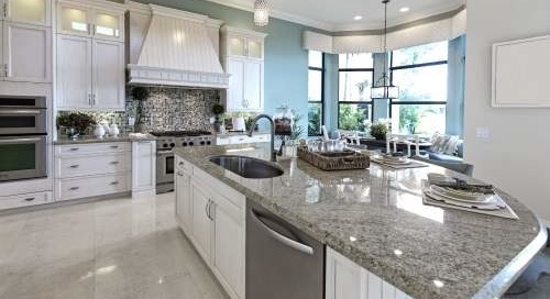 A large kitchen with granite counter tops and white cabinets.