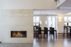 A room with a fireplace and dining table.