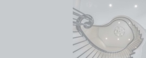 A spiral staircase with metal railing and white walls.