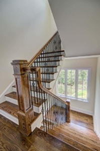 A staircase with wooden steps and iron railing.