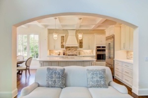 A white couch in the middle of a kitchen.