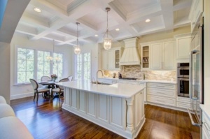 A kitchen with white cabinets and wooden floors