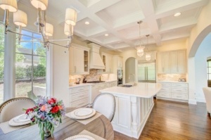 A kitchen with white cabinets and wooden floors.