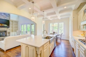 A kitchen with white cabinets and wooden floors.