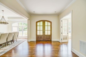 A large room with two doors and a table in the center.