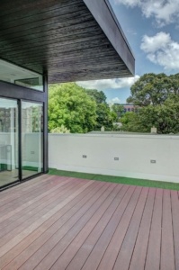 A large deck with a view of the trees.