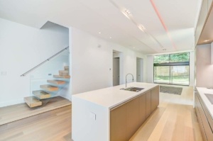 A kitchen with a sink and stairs in it