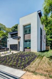 A modern house with a car parked in front of it.