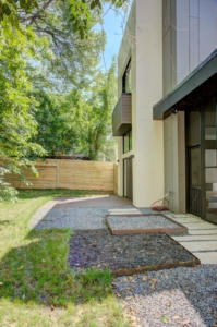 A house with a paved walkway and trees
