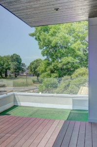 A balcony with a view of trees and a road.