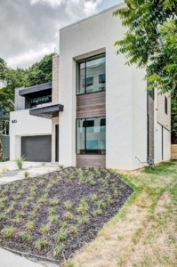 A modern house with a garage and lots of windows.