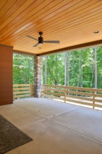 A large open porch with a ceiling fan.