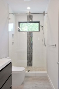 A bathroom with a toilet, shower and sink.