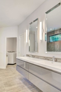 A bathroom with two sinks and a large mirror.
