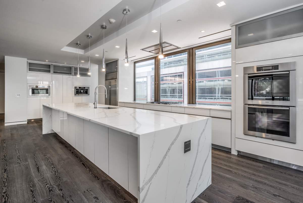 A large kitchen with white cabinets and island