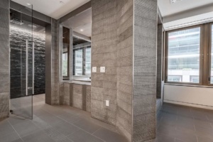 A room with a large mirror and stone walls.