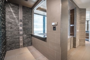 A bathroom with a large window and tiled walls.