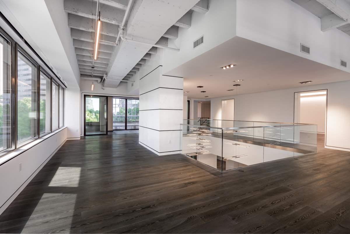 A large room with wooden floors and white walls.