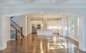 A large kitchen with white cabinets and wood floors.