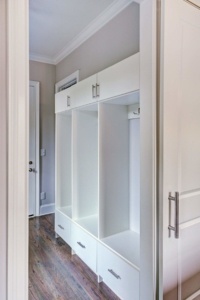 A white locker room with two drawers and three open compartments.