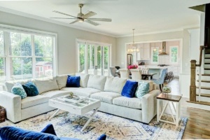 A living room with white furniture and blue pillows.