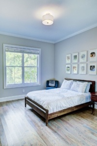 A bedroom with a bed, nightstand and window.