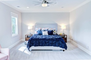 A bedroom with a bed, two nightstands and lamps.