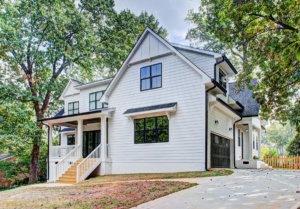 A white house with black trim and a driveway.