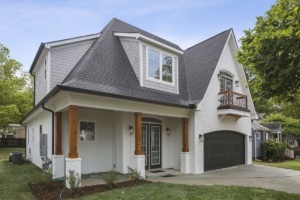 A large white house with a black garage door.