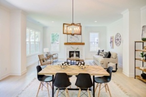 A dining room table with black chairs and a fireplace.