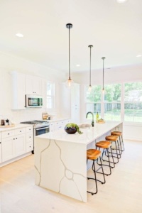 A kitchen with white cabinets and island in it