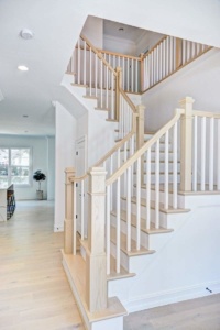 A white staircase with wooden handrails and spindles.