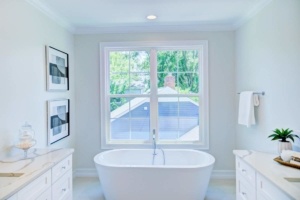 A bathroom with a tub and two sinks.