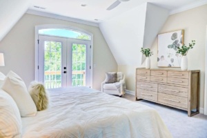A bedroom with white walls and furniture.