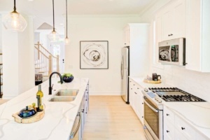 A kitchen with white cabinets and black appliances.