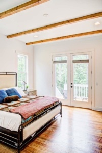 A bedroom with a bed and two windows.
